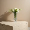 A transparent carved glass vase with a white rose bouquet for home decoration details Picture